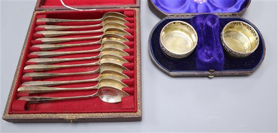 A cased pair of Victorian silver salts and a cased set of twelve white metal spoons.